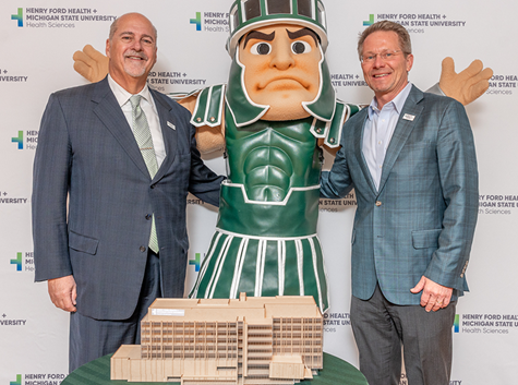 Henry Ford Health President and CEO Bob Riney, Sparty, and MSU President Kevin M. Guskiewicz, Ph.D.